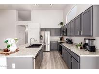 Modern kitchen featuring gray cabinets, stainless steel appliances, granite countertops, and recessed lighting at 11622 W Palm Brook Dr, Avondale, AZ 85392