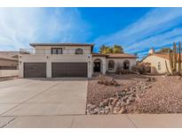 Inviting two-story home featuring a balcony, beautiful desert landscaping, and a spacious three-car garage at 15806 N 45Th Pl, Phoenix, AZ 85032