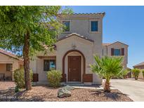 Charming two-story home with a well-manicured lawn and inviting front entrance at 17471 W Watson Ln, Surprise, AZ 85388