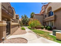 Charming condo exterior with a well-maintained walkway, lush landscaping, and vibrant desert foliage at 1905 E University Dr # 139, Tempe, AZ 85288