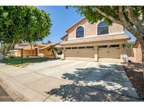 Traditional two-story home featuring a three-car garage and mature landscaping at 20657 N 56Th Ave, Glendale, AZ 85308