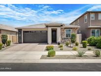 Charming single-story home with stone accents, a two-car garage, and well-maintained landscaping at 22476 E Indiana Ave, Queen Creek, AZ 85142