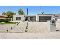Charming home featuring desert landscaping, decorative stone walkway, and a two-car garage at 4842 E Surrey Ave, Scottsdale, AZ 85254