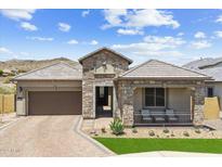 Charming single-story stone home boasts a covered porch with seating and a well-manicured desert landscape at 520 E Ashurst Dr, Phoenix, AZ 85048