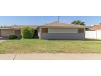 Charming single-story home features a well-maintained lawn and a classic desert landscape at 6009 W Medlock Dr, Glendale, AZ 85301