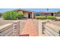 Charming single-story home featuring a brick pathway and inviting front entrance, with mature landscaping at 6217 W Orange Dr, Glendale, AZ 85301