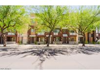 Street view of modern townhomes with well-maintained landscaping and trees along the sidewalk at 6605 N 93Rd Ave # 1035, Glendale, AZ 85305