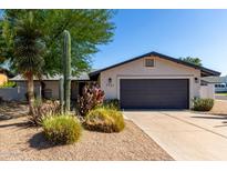 Charming home with desert landscaping, featuring a two-car garage and a well-maintained front yard at 7731 E Rose Ln, Scottsdale, AZ 85250