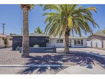 Charming single-story home with a well-maintained gravel yard and mature palm trees at 8137 E Indian School Rd, Scottsdale, AZ 85251