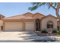 Charming home featuring a three-car garage, tile roof, and desert landscaping at 13657 W Holly St, Goodyear, AZ 85395