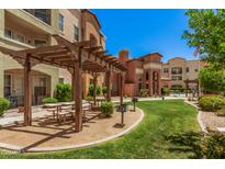 Beautiful community area with a wooden pergola, picnic tables, and well-maintained landscaping at 14575 W Mountain View Blvd # 12309, Surprise, AZ 85374