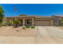 Charming single-story home featuring a neutral color scheme, well-maintained landscaping, and an American flag at 17796 W Andora St, Surprise, AZ 85388