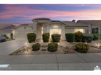 Charming single-story home with a well-manicured front yard and desert landscaping at sunset at 19102 N 91St St, Scottsdale, AZ 85255