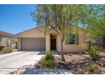 Charming single-story home featuring a two-car garage and desert landscaping in front at 1965 N 213Th Dr, Buckeye, AZ 85396