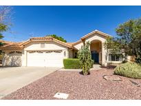 Charming single-story home featuring a tile roof, desert landscaping, and a two-car garage at 319 N Riata St, Gilbert, AZ 85234