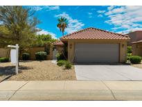 Charming single-story home with a tile roof, two-car garage, and desert landscaping under a partly cloudy blue sky at 4225 E Sandia St, Phoenix, AZ 85044