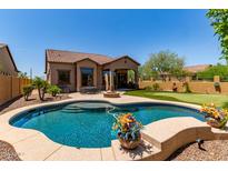 Inviting pool with a fire pit, covered patio, and a mini putting green in the beautifully landscaped backyard at 8304 E Inca St, Mesa, AZ 85207