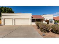 Charming single-story home featuring a three-car garage, desert landscaping, and a classic red tile roof at 15602 N 19Th St, Phoenix, AZ 85022