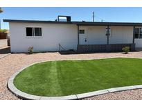 Well-maintained home featuring desert landscaping, a small lawn, and a charming covered porch at 2023 W Wayland Rd, Phoenix, AZ 85041