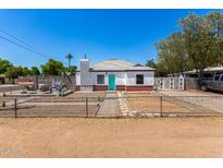 Charming home with red brick accents, white paint and a bright turquoise front door at 2802 E Virginia Ave, Phoenix, AZ 85008