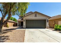 Charming single-Gathering home with a two car garage, desert landscaping, and a beautiful shade tree at 41251 W Cahill Dr, Maricopa, AZ 85138