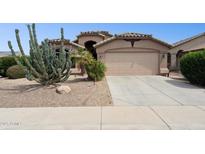 Charming home with desert landscaping, a two-car garage, and a well-maintained lawn at 42076 W Colby Dr, Maricopa, AZ 85138