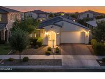 Charming single-story home featuring a two-car garage, landscaped front yard, and welcoming entryway at sunset at 4346 S Synapse Dr, Mesa, AZ 85212