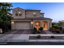 Exterior front view of a two-story house featuring a two-car garage and a covered porch with inviting outdoor seating at 5016 S Curie Way, Mesa, AZ 85212