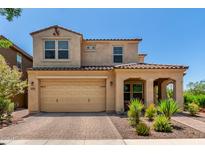 Charming two-story home with a two-car garage, covered entry, and desert landscaping in the front yard at 5016 S Curie Way, Mesa, AZ 85212