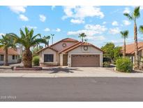 Charming single-story home featuring a two-car garage and a well-maintained front yard with mature palm trees at 6719 W Sack Dr, Glendale, AZ 85308