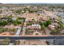 Expansive aerial view showcasing a horse property with a large riding arena and a custom home in a desert landscape at 6861 W Calle Lejos --, Peoria, AZ 85383