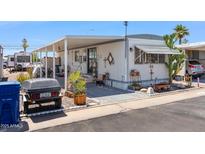 Charming mobile home featuring covered patio and unique outdoor decor at 7807 E Main St # E2, Mesa, AZ 85207