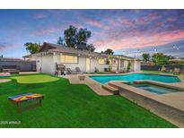Backyard oasis showcasing a pool, hot tub, putting green, and ample seating areas at 818 N Terrace St, Mesa, AZ 85203