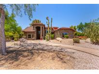 Stunning stone home with a beautiful arched entryway and desert landscaping with mature Saguaro cacti at 8606 S Dorsey Ln, Tempe, AZ 85284
