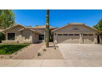 Charming single-story home featuring desert landscaping, a three car garage, and a tile roof at 9112 E Palm Tree Dr, Scottsdale, AZ 85255