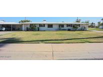 Charming single story home with a well-maintained lawn, mature trees, and covered parking at 10307 W Oakmont Dr, Sun City, AZ 85351
