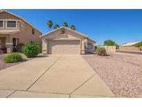 Charming single-story home with a two-car garage, desert landscaping, and sunny skies at 15440 W Mauna Loa Ln, Surprise, AZ 85379