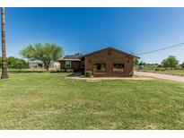Charming single story home with solar panels, desert landscaping and a large grassy front yard at 19302 W Melvin St, Buckeye, AZ 85326