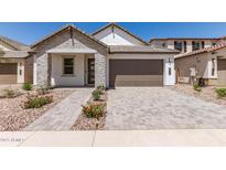 Charming single-story home featuring stone accents, a two-car garage, and beautiful desert landscaping at 19434 S 212Th Pl, Queen Creek, AZ 85142
