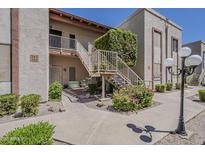 Inviting condo exterior with lush landscaping, stairway, and a charming bicycle display at 205 N 74Th St # 261, Mesa, AZ 85207