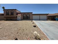 Charming home featuring a three-car garage, a low maintenance yard and a classic desert aesthetic at 3145 W Acoma Dr, Phoenix, AZ 85053