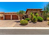 Charming stone home featuring a two-car garage, desert landscaping, and a brick driveway at 4041 N Silver Ridge Cir, Mesa, AZ 85207