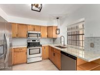 Bright kitchen features stainless steel appliances, granite countertops and wooden cabinetry at 4901 E Kelton Ln # 1251, Scottsdale, AZ 85254