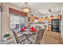 Cozy dining area with modern light fixture, seating for four, and views to the kitchen at 7401 W Arrowhead Club Dr # 2067, Glendale, AZ 85308
