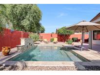 Sparkling pool featuring a stone water feature and umbrella shaded lounge area at 10786 W Chisholm Dr, Sun City, AZ 85373