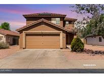 Inviting two-story home featuring a two-car garage, terracotta roof, and low-maintenance desert landscaping at 12228 N 122Nd Dr, El Mirage, AZ 85335