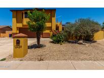 Charming two-story home featuring a bright mustard exterior, well-maintained landscaping, and a quaint front yard at 12459 N 36Th St, Phoenix, AZ 85032
