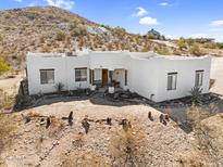 Charming white home with desert landscaping and mountain backdrop, creating a serene Southwestern setting at 1550 W Adobe Dam Dr, San Tan Valley, AZ 85144