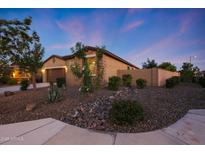 Charming single-story home featuring stone accents, low-maintenance landscaping, and a two-car garage at dusk at 18835 W San Miguel Ave, Litchfield Park, AZ 85340