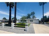 Charming home with solar panels and a beautifully landscaped front yard with palm trees at 2201 N 29Th Pl, Phoenix, AZ 85008